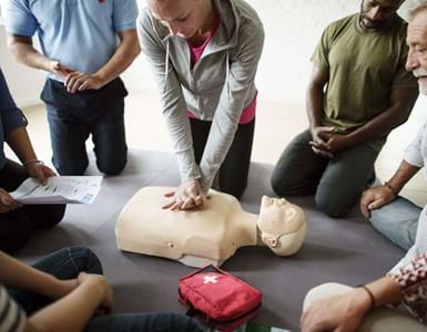 group of employees in an office learning CPR first aid training at the office