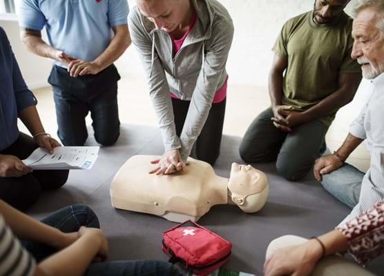 group of employees in an office learning CPR first aid training at the office
